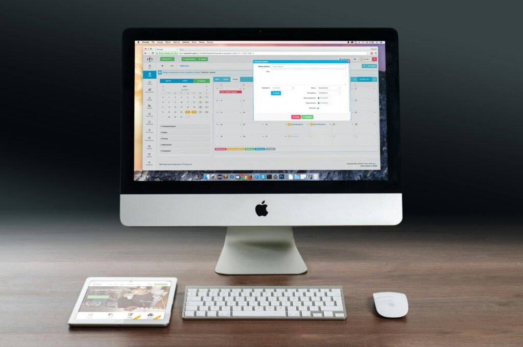 apple-imac-ipad-workplace-38568-38568 A sleek office setup featuring an Apple iMac, iPad, and keyboard on a wooden desk.