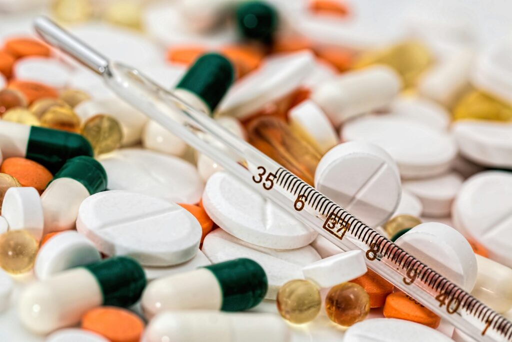thermometer-headache-pain-pills-139398-139398 Close-up image showing various pills and a thermometer, emphasizing health and medicine.